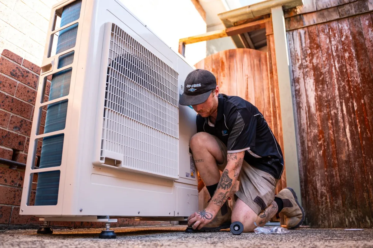 A DPK technician servicing an outdoor air conditioning unit