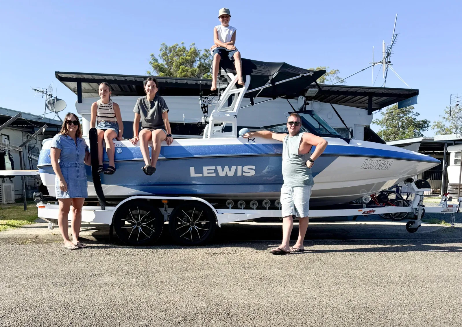 Nathan and Ebony with their family and a Lewis boat