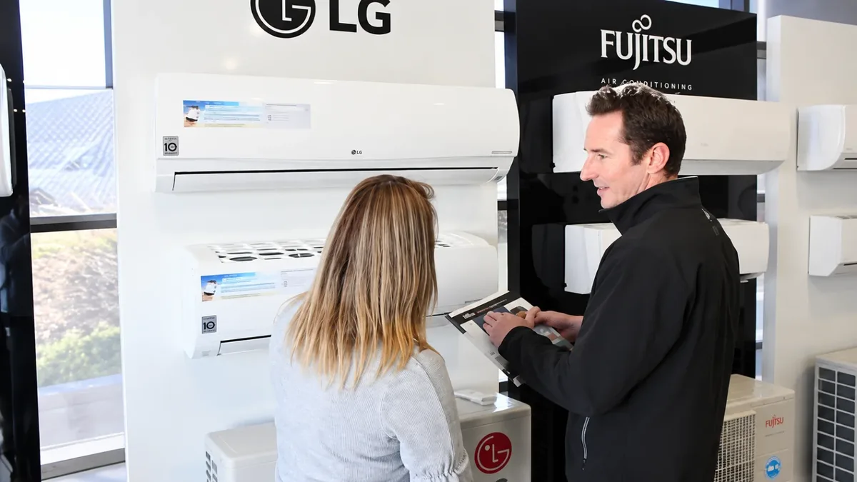 A customer and a team member at an LG and Fujitsu air conditioner display