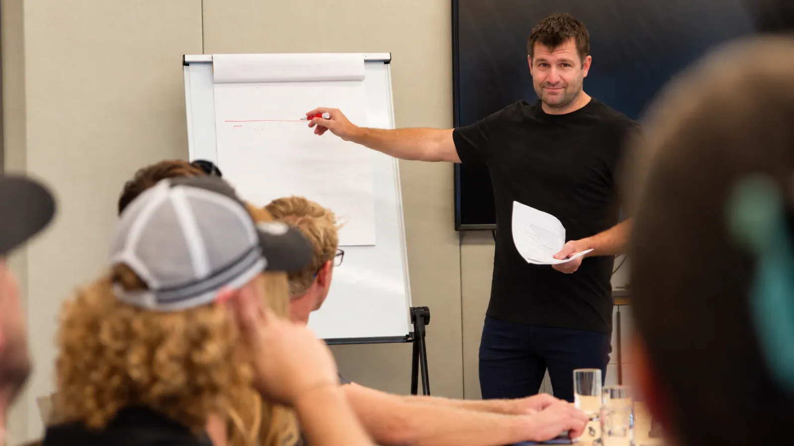 A presenter at a flipchart running a session for a small group