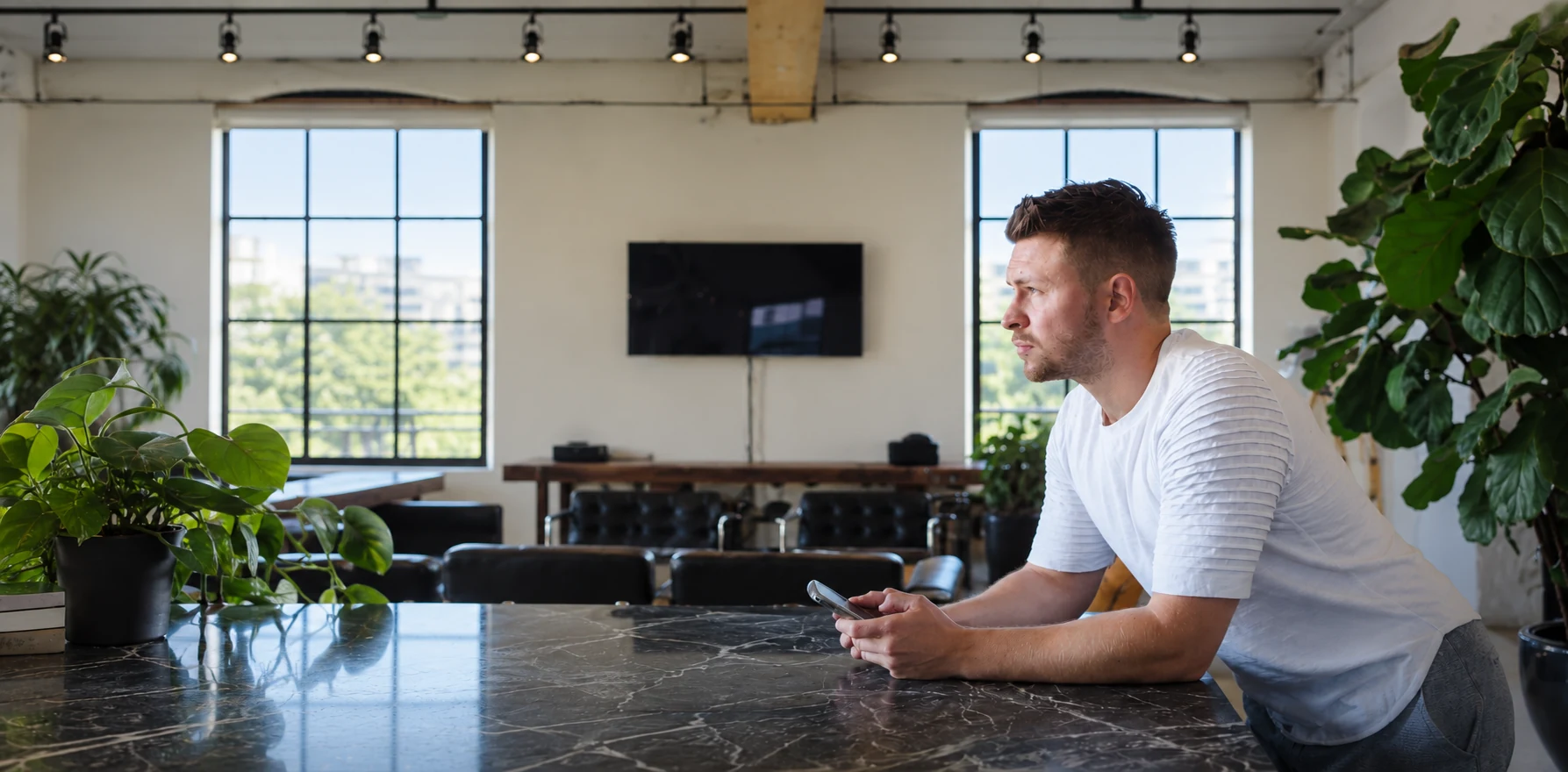 A business owner pausing at a bench with his phone